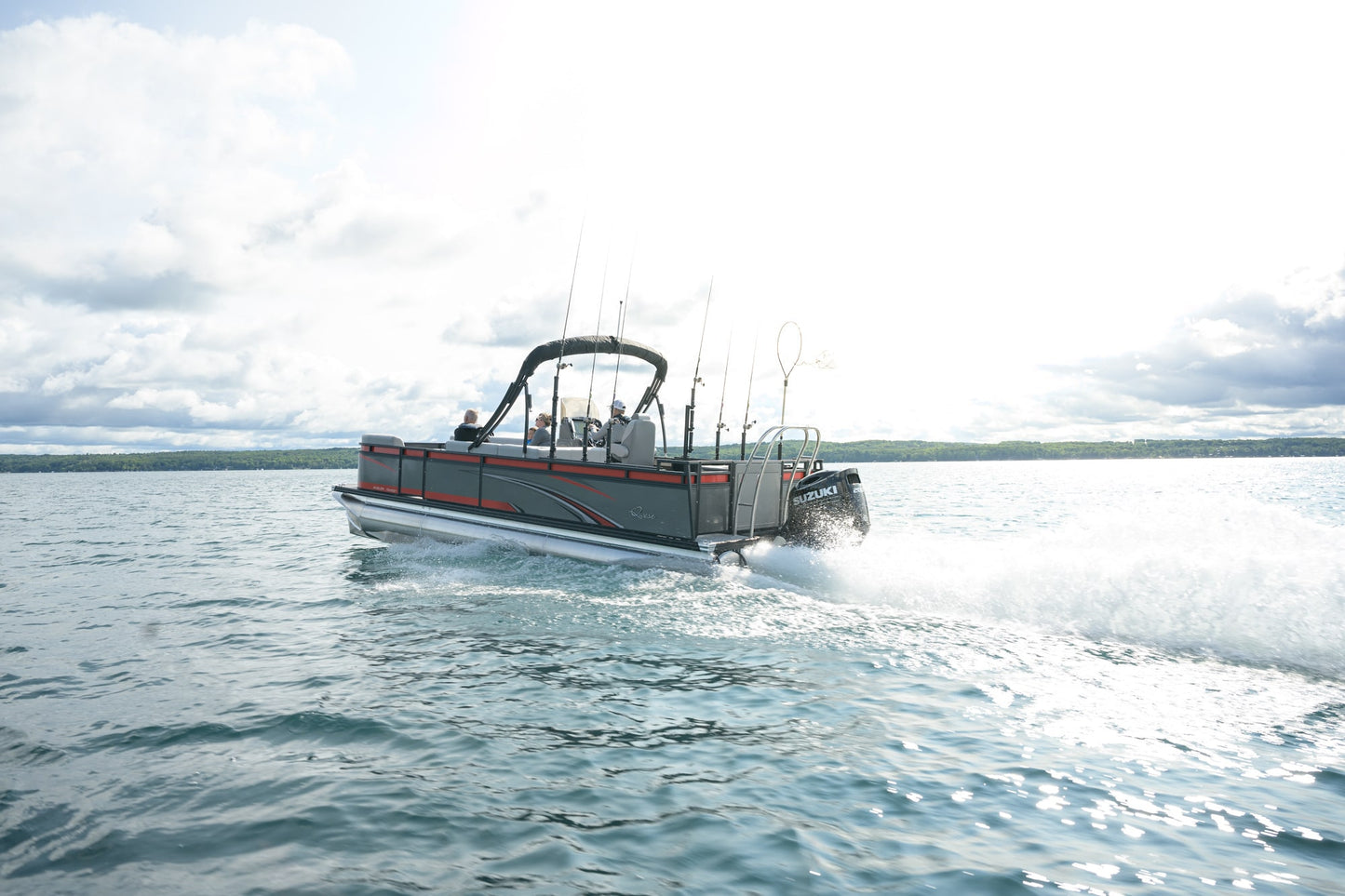 Ponton boat with Suzuki 115 on a lake with a cloudy sky